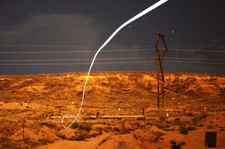 Snímek zachycuje letovou dráhu navádné munice bhem noní zkouky. Na stele byla pipevnna malá LED dioda a fotografie byla poízena s delí uzávrkou.