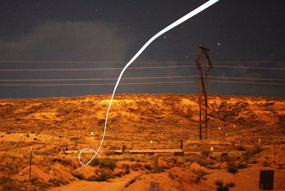 Snímek zachycuje letovou dráhu navádné munice bhem noní zkouky. Na stele byla pipevnna malá LED dioda a fotografie byla poízena s delí uzávrkou.