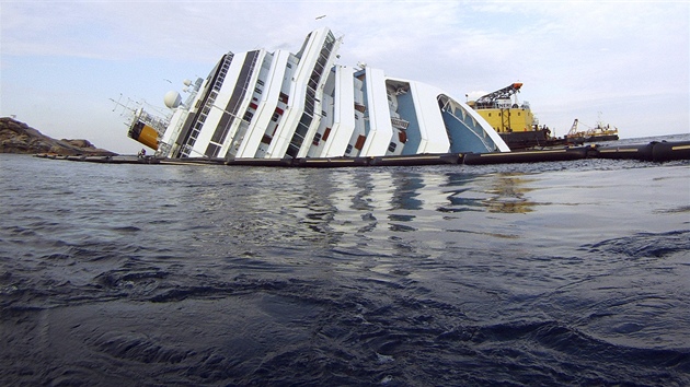 Rackové létají kolem vraku lodi Costa Concordia u ostrova Giglio. (30. ledna 2012)