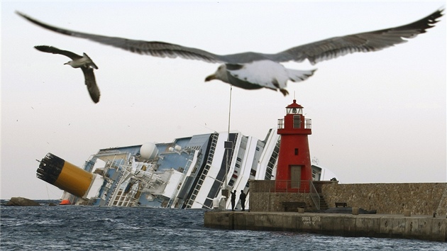 Rackové létají kolem vraku lodi Costa Concordia u ostrova Giglio (30. ledna...