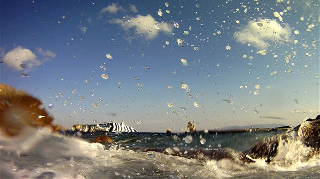 Rackové létají kolem vraku lodi Costa Concordia u ostrova Giglio. (30. ledna 2012)