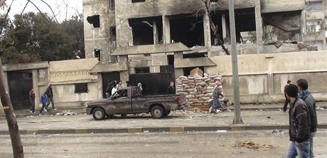 Syané se dívají ve mst Homs na budovu pokozenou boji mezi povstalci a