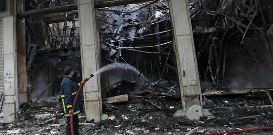 Hasi kropí vypálený obchod, který padl za ob noním protestm. (13. února