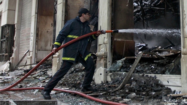Hasi kropí vypálený obchod, který padl za ob noním protestm. (13. února...