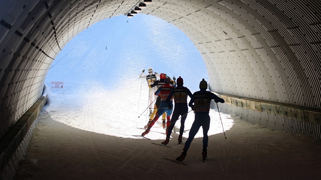 SVĚTLO NA KONCI TUNELU. Lyžaři projíždějí tunelem během závodu štafet. SVĚTLO NA KONCI TUNELU. Lyžaři projíždějí tunelem během závodu štafet.