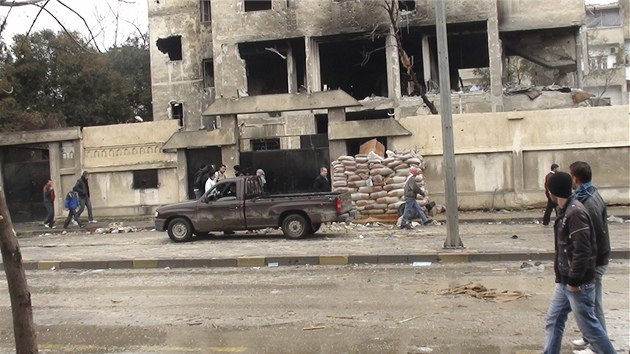 Syan se dvaj ve mst Homs na budovu pokozenou boji mezi povstalci a syrskou armdou. (10. nora 2012)