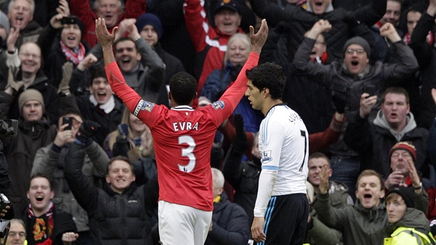 ODPLATA. Petrice Evra se raduje z glu Manchesteru United, zatmco liverpoolsk Luis Surez za nm jen smutn prochz.