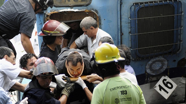 Zchrani vyprouj zrann pasary z havarovanho pmstskho vlaku, kter nedobrzdil ve stanici. Buenos Aires, Argentina (22. nora 2012)