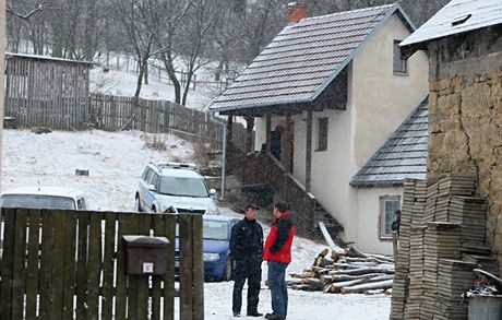 Policist hldkuj u domu v Doubravch na Zlnsku. Zbran nali v budov vzadu.