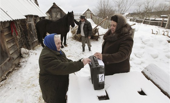 Ruská babika vhazuje svj hlas do mobilní volební urny ve vesnici