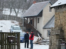 Policist hldkuj u domu v Doubravch na Zlnsku. Zbran nali v budov vzadu.