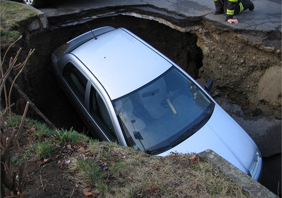 Auto museli z tímetrové jámy vytáhnout hasii jeábem.