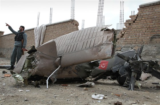 Afghánský policista ukazuje, jak turecká helikoptéra havarovala. (16. bezna