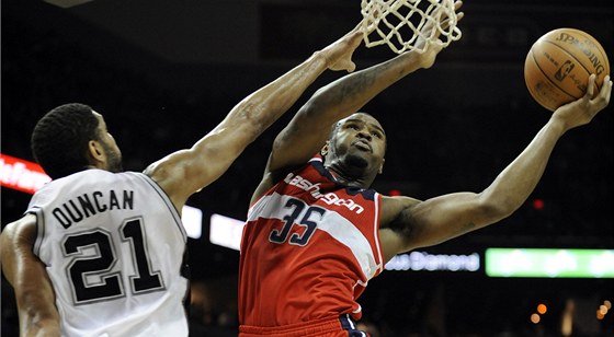 Trevor Booker z Washingtonu se vyhýbá bloku Tima Duncana ze San Antonia.