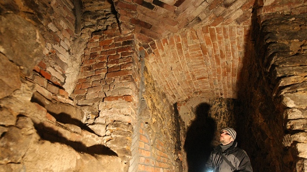 Archeolog Marek Peka ukazuje pvodní gotickou klenbu ve sklep budovy