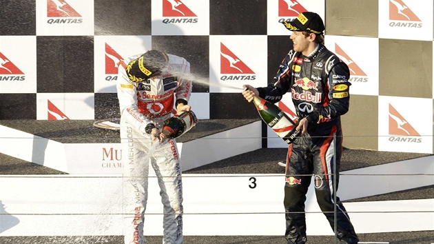 SPRCHA PRO VTZE. Obhjce titulu mistra svta Sebastian Vettel (vpravo) svlauje vtze Jensona Buttona proudem ampaskho.