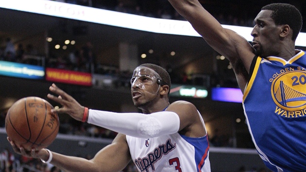 MASKOVANÝ. Chris Paul z LA Clippers zakonuje kolem Ekpeho Udoha z Golden State.