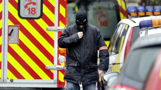 Maskovaný francouzský policista prochází nedaleko budovy, ve které se...