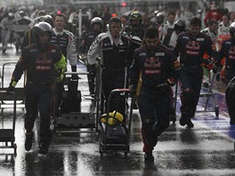 RYCHLE POD STECHU. Mechanici stáje Red Bull (v popedí) se spolu s ostatními...
