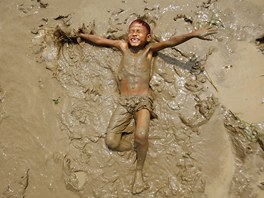 Barmský chlapec dovádí v bahn na behu eky Bago. (20. bezna
