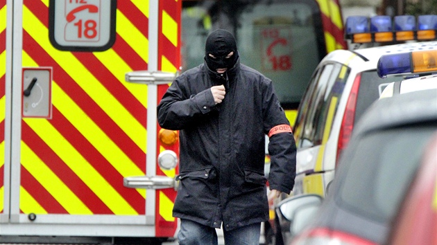 Maskovan francouzsk policista prochz nedaleko budovy, ve kter se zabarikdoval mu podezel z pondln stelby v Toulouse, pi kter byli zabiti tyi lid. (21. bezna 2012)
