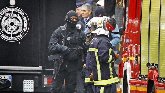 Francouzsk policista ze zsahov jednotky a hasii nedaleko domu, ve kterm se zabarikdoval Mohammed Merah. (22. bezna 2012)
