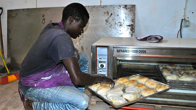 Jeden z peka Domingos Henriquez obrací chléb v troub v pekárn v Cuemb