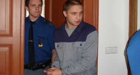 Bývalý policista Stanislav Kubata pichází v doprovodu eskorty do soudní sín. 
