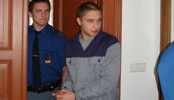 Bývalý policista Stanislav Kubata pichází v doprovodu eskorty do soudní sín. 