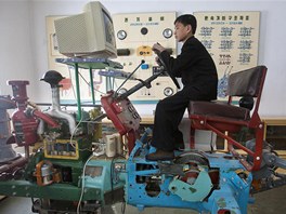 Severokorejský student se na dmyslném simulátoru traktoru uí umní orby.