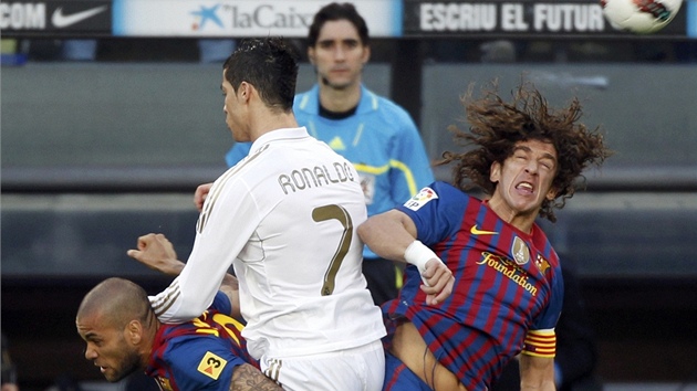 VZDUN SOUBOJ. Cristiano Ronaldo z Realu Madrid jich s barcelonskm Carlesem Puyolem svedl bezpoet, tentokrt se k nim pipletl jet Dani Alves (vlevo).