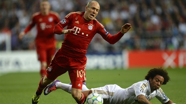 PÁD. Arjen Robben z Bayernu se kací na trávník po souboji s Marcelem z Realu