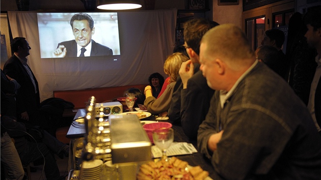 Francouzi sleduj pedvolebn televizn debatu mezi Francoisem Hollandem a Nicolasem Sarkozym (na snmku v televizi) (2. kvtna 2012)