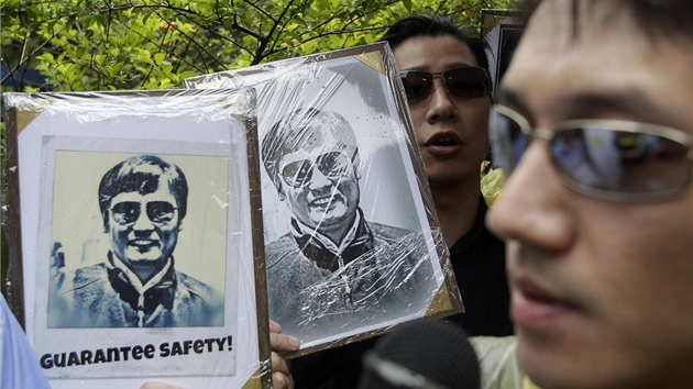 Aktivisté drí portréty chen Kuang-chenga ped Americkým institutem na