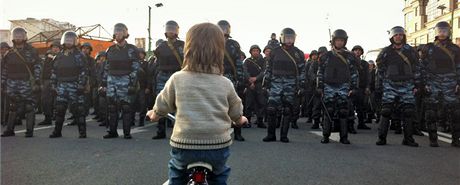 Chlapec na kole stojí proti kordonu ruských policist