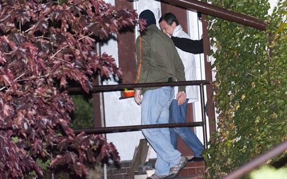 David Rath v doprovodu policist odchází ze svého domku v Hostivici.