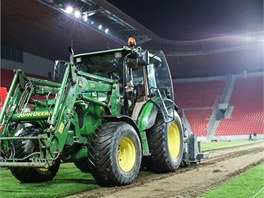 Traktory likvidovaly ást travnatého povrchu stadionu dlouho do noci.