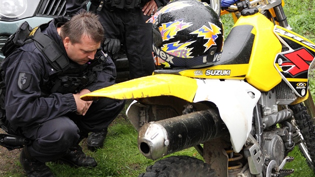 Policista pi ztahu v Beskydech kontroluje motocykl.