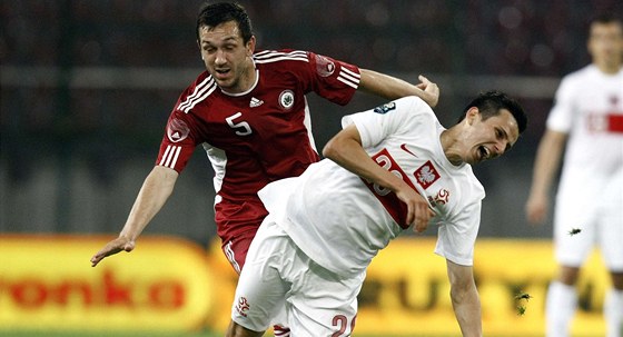 Polský fotbalista Rafal Wolfski (vpravo) v souboji s Olegsem Laizanem z týmu