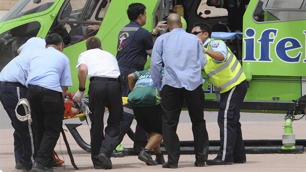 Záchranái nakládají zranné do vrtulníku po poáru obchodního centra v