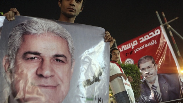 Pznivce prezidentskho kandidta Hamdna Sabbhho dr jeho podobiznu v poped ped velkmi plakty jednoho z favorit Muhammada Mursho (20. kvtna 2012)