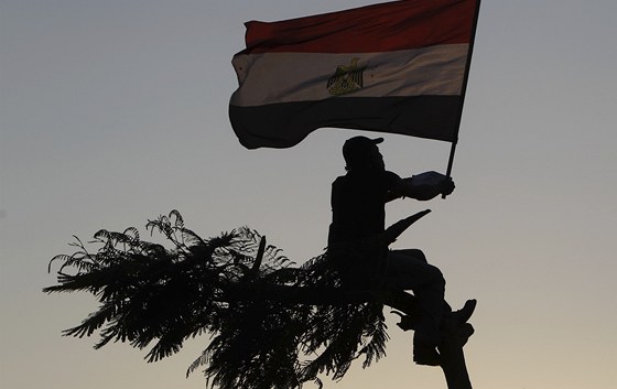 Egypan mává vlajkou na káhirském námstí Tahrír. Davy lidi vyrazily do ulic v
