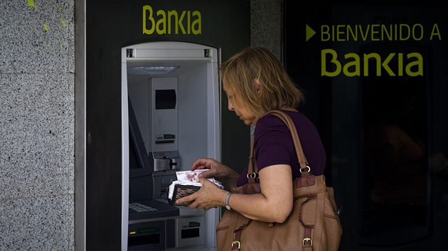 Žena u bankomatu nejproblémovější španělské banky Bankia. Ilustrační snímek Žena u bankomatu nejproblémovější španělské banky Bankia. Ilustrační snímek