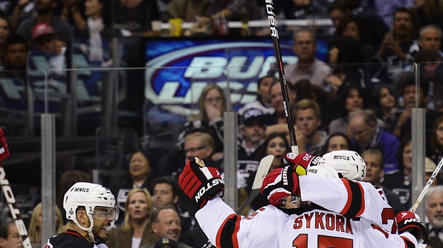 ELI M SKORKU. Radost hokejist New Jersey po prvn brance tvrtho finlovho utkn hokejovho Stanley Cupu do st Los Angeles. Na snmku jsou Bryce Salvador (vlevo), Petr Skora (15) a Patrik Eli.