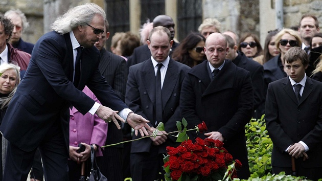 Hudebník Barry Gibb pokládá ri na hrob pi pohbu zesnulého bratra Robina.