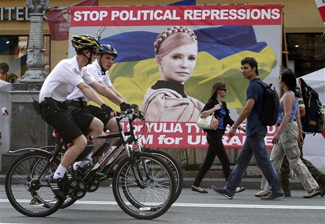 Lidé v centru Kyjeva míjejí billboard s Julijí Tymoenkovou a výzvou Stop