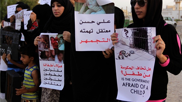 eny a dti demonstruj proti zatkn dt. Prominentn bojovnice za lidsk prva Zainab al-Khawaja (vpravo) dr plakt s dvojjazynm textem, zda se vlda boj dt. 
