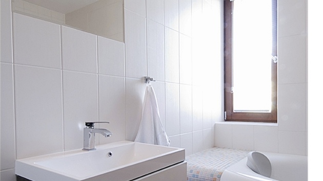 Koupelna evokuje svými bílými lesklými plochami a oblými liniemi pocit istoty