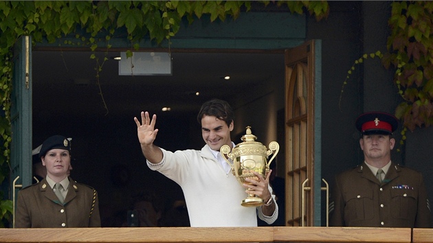 TOHLE JE ONA. Roger Federer mv divkm z balkonu ve wimbledonskm arelu se svou sedmou vtznou trofej.