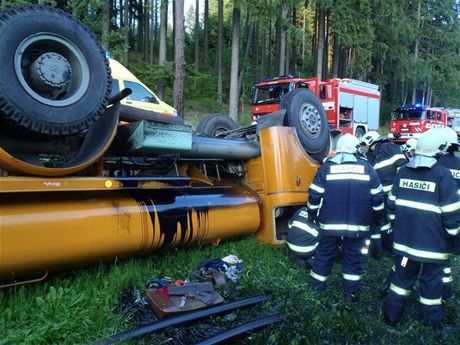 Hasii vyproují zranného idie z kropicího vozu, který se pevrátil u